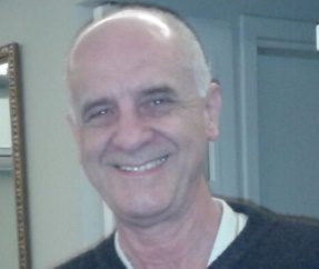 Homem sorrindo posando para foto Descrição gerada automaticamente