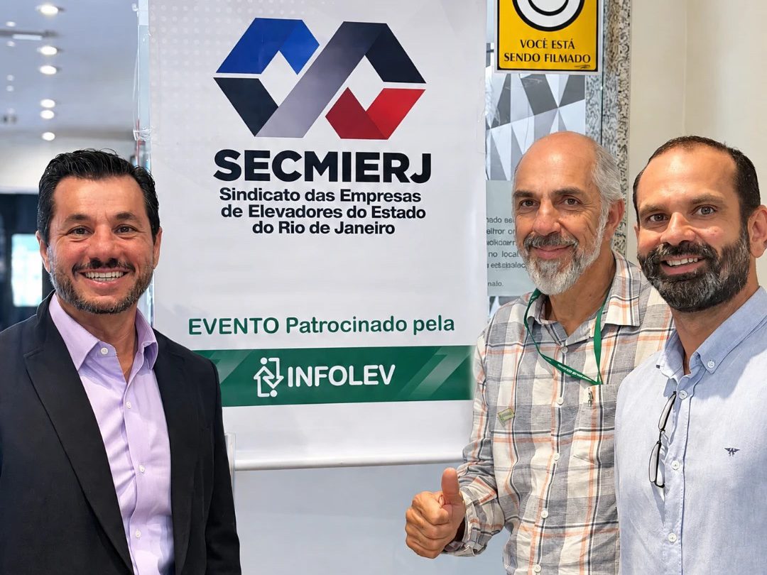Leandro Barbalho e dois participantes diante do banner do SECMIERJ com o patrocínio da Infolev